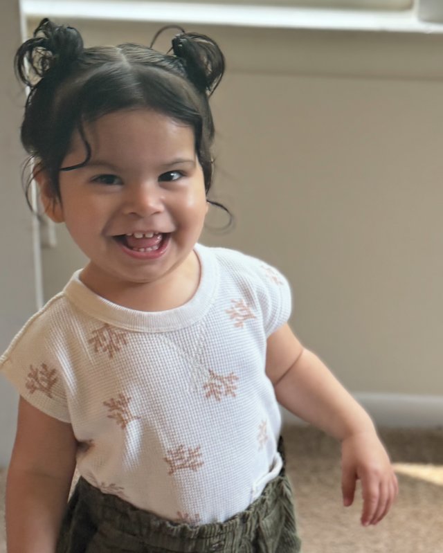 Eliany laughing with her hair in two buns